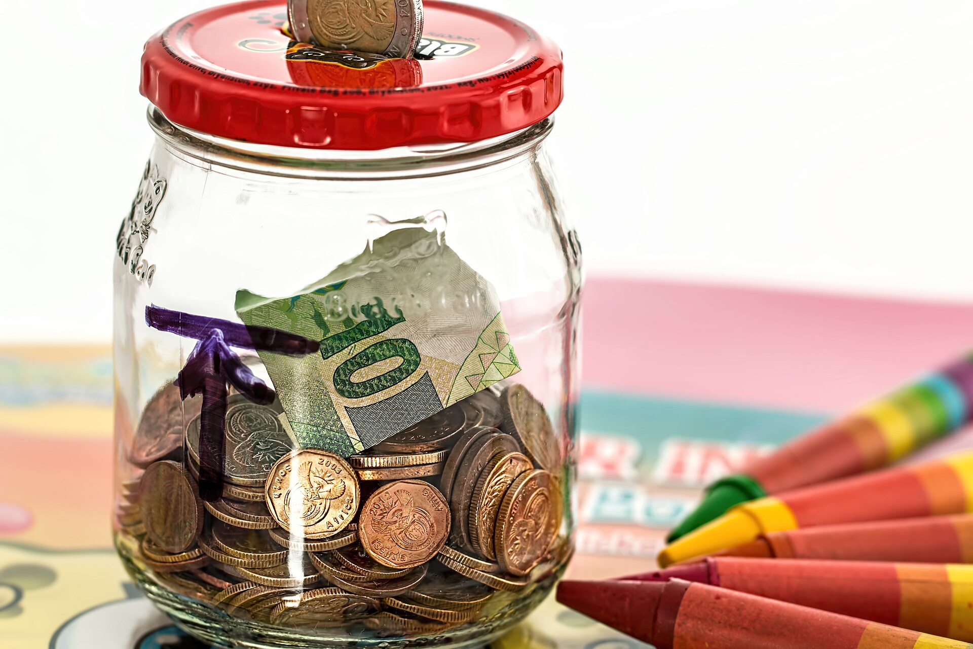 Pote de vidro com moedas e notas guardadas